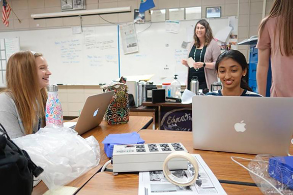 : Maddie Baden, left, and Gina Mathew laugh with journalism teacher Emily Smith about their tribulations in putting together a story that resulted in the incoming principal resigning. At the time, they were very nervous, they said.    Photo by Oliver Morrison, The Wichita Eagle